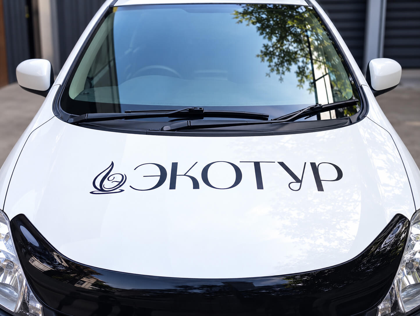 Логотип ЭКОТУР на капоте автомобиля